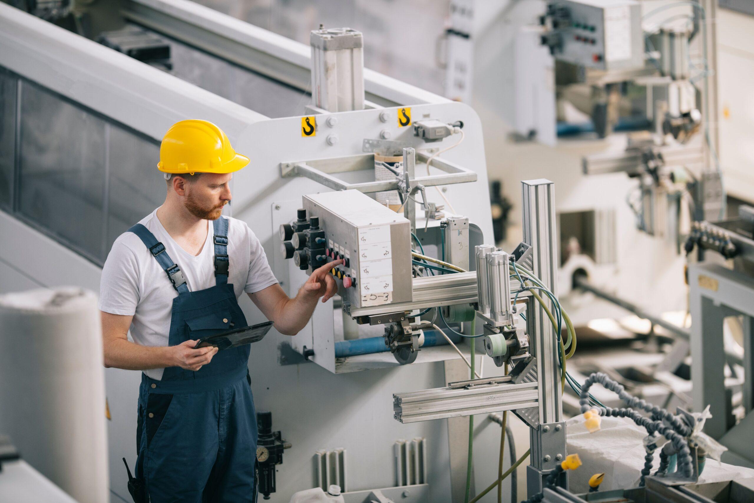 Bediener prüft Steuereinheit einer Industrieanlage