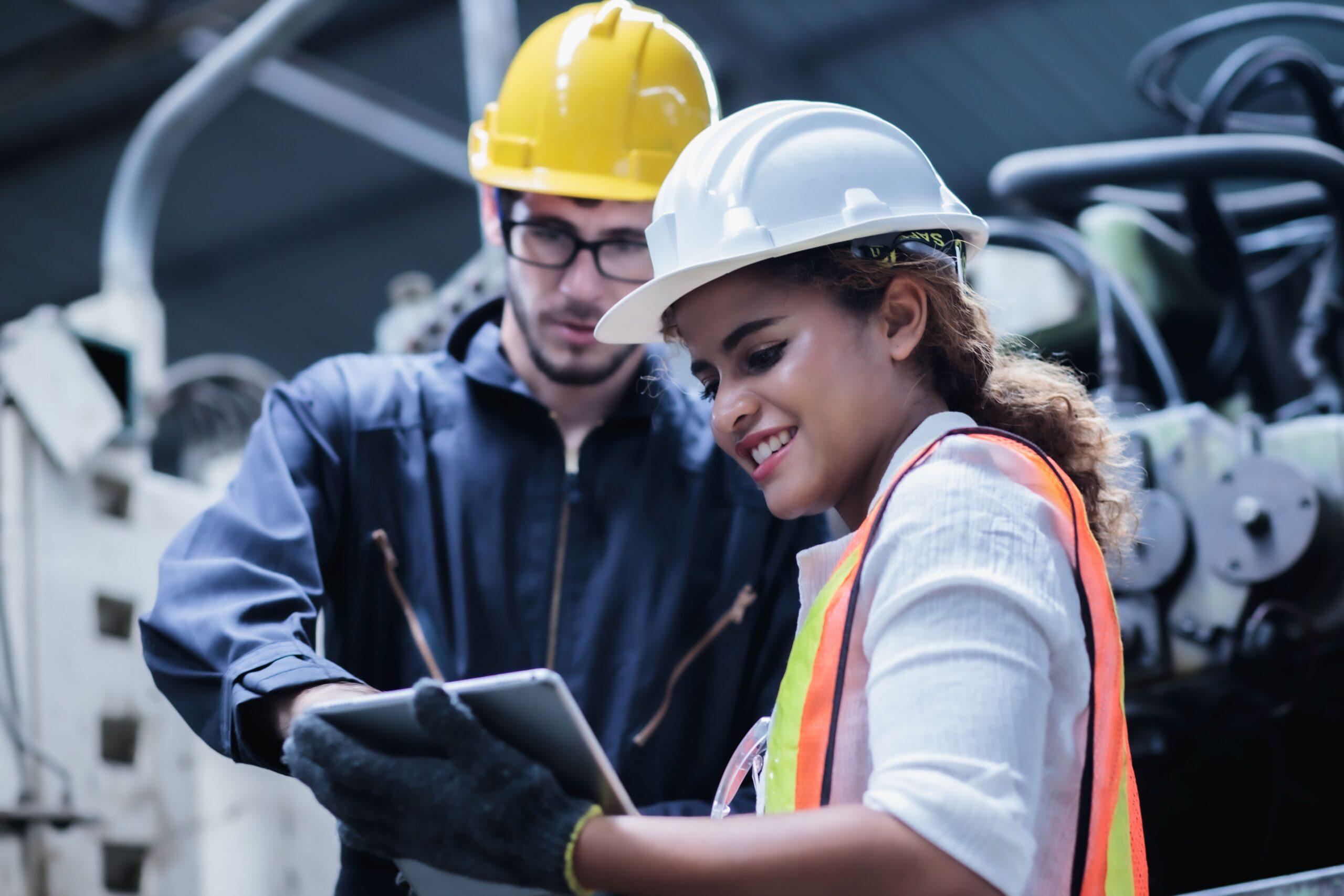 Zwei Mitarbeitende im Gespräch vor Industrieanlage