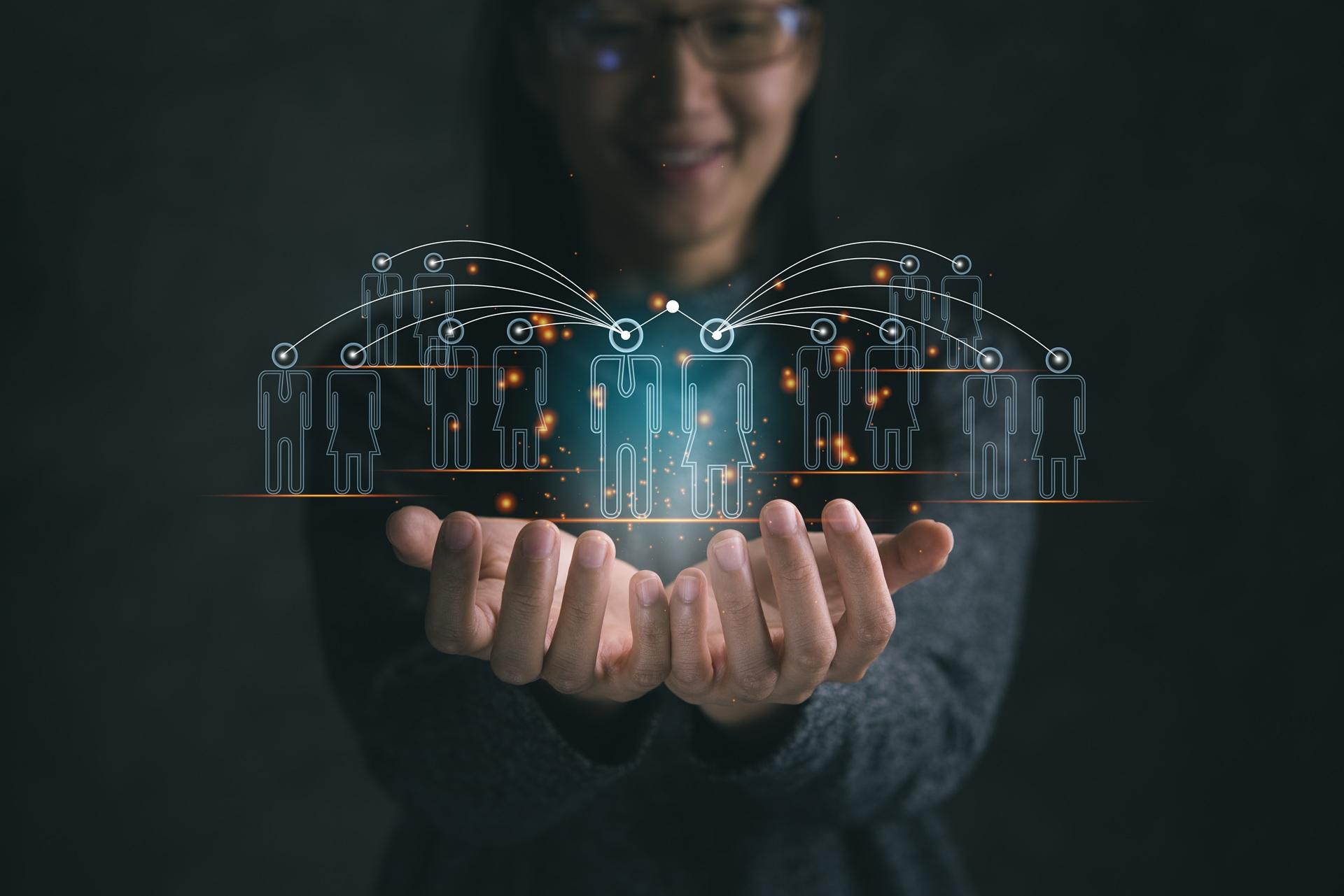 Hände halten digitales Netzwerk aus verbundenen Personen | KI Lösungen